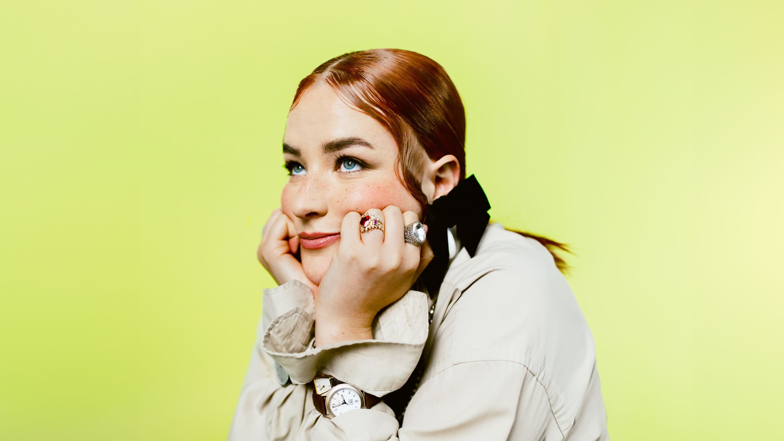 A woman staring into the distance yellow background