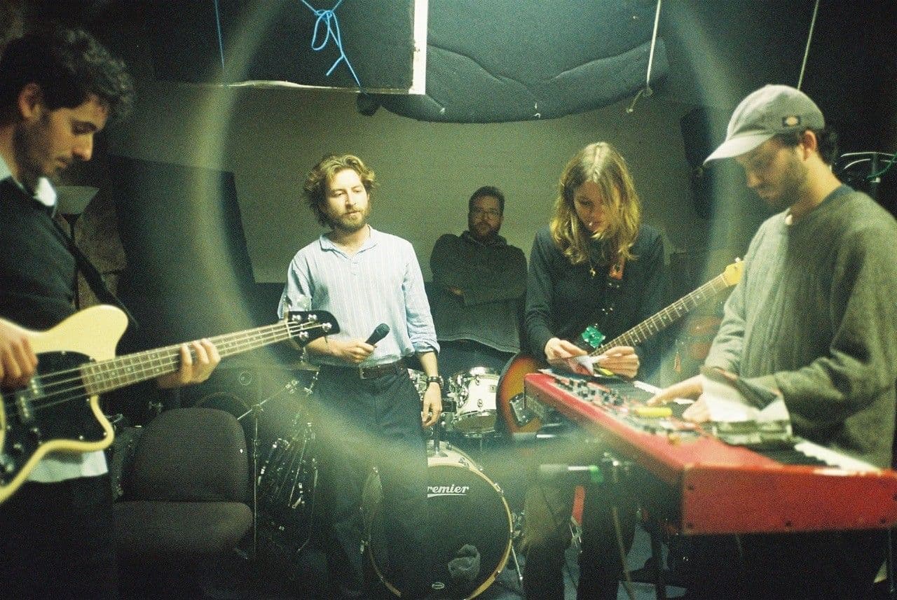 A diverse group of musicians playing various instruments in a professional studi.