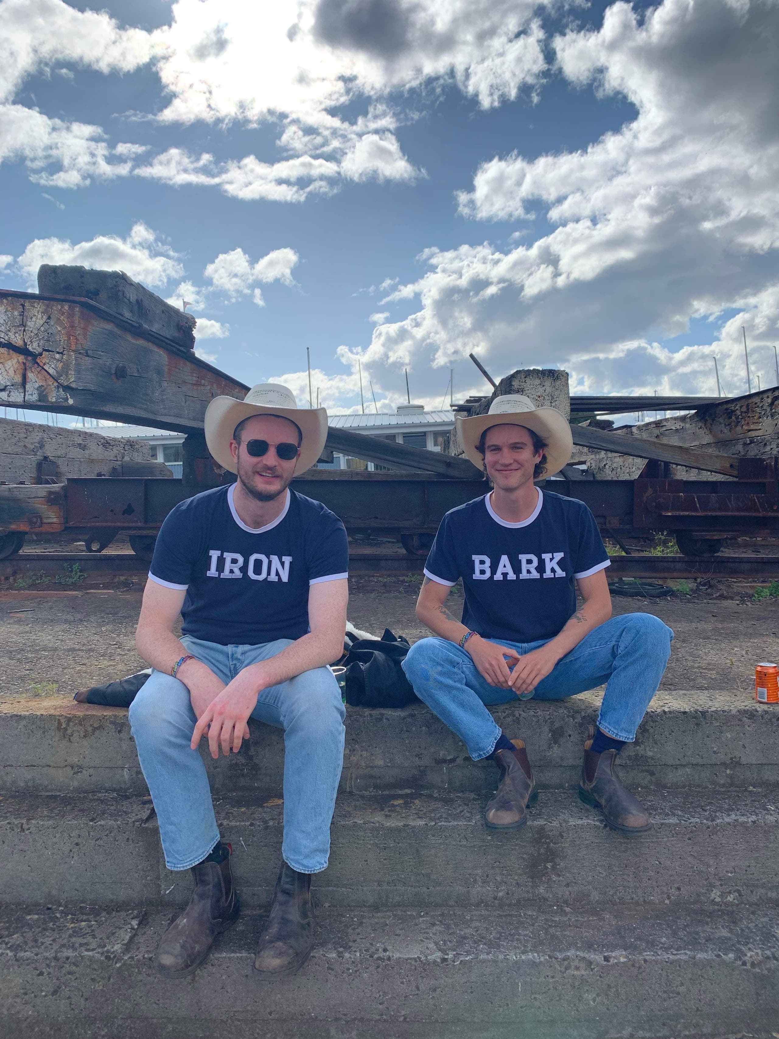 Two men sitting on stairs with cowboy hats.
