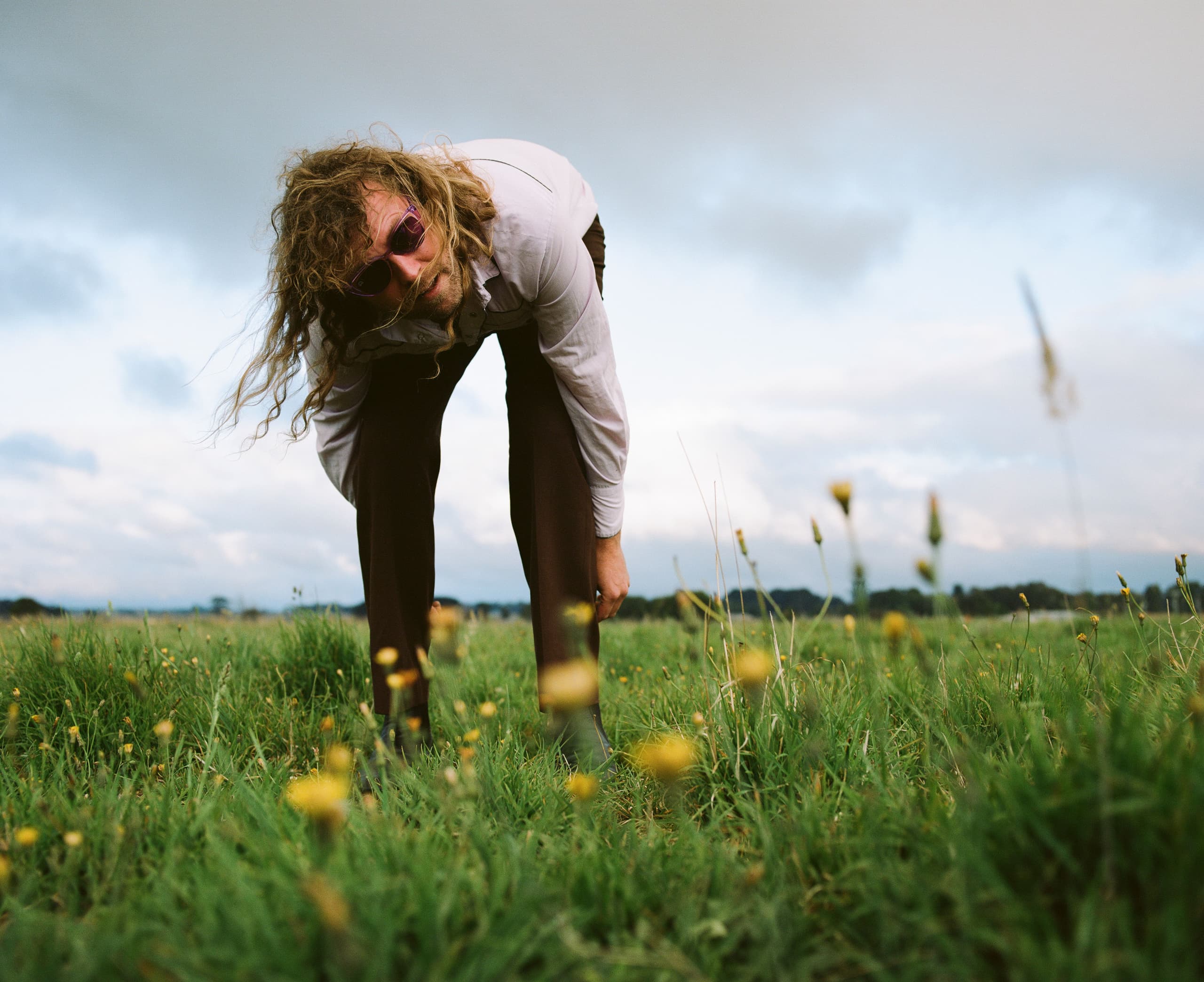 A man leaning forward in a field
